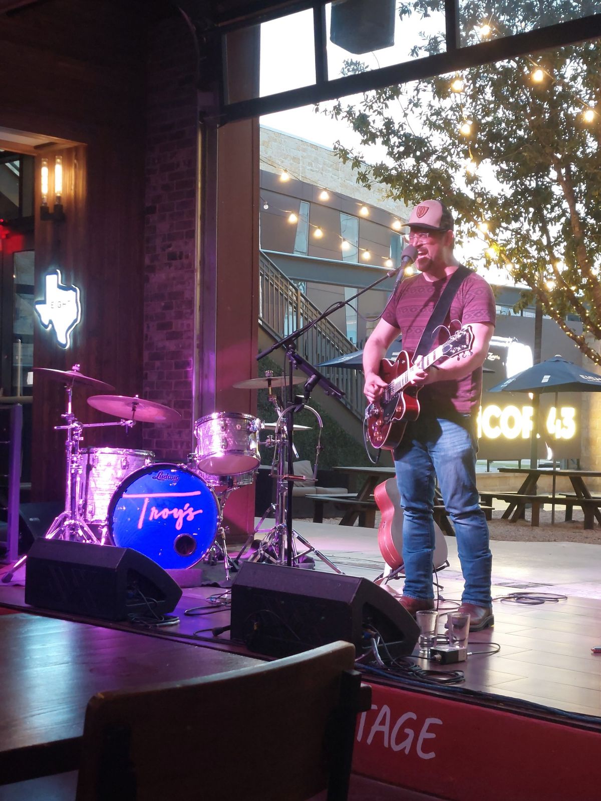 Wilhyme playing a red electric guitar on stage